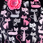 Cadeau de noel pour foodie. Joli tablier à motif de chats. Des chats rose et gris sur coton noir. Ceinture, poches et volant sont rose avec des pois blanc